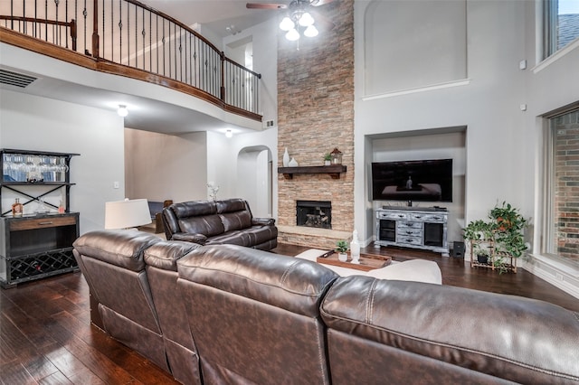 living room with hardwood / wood-style floors, a high ceiling, ceiling fan, and visible vents