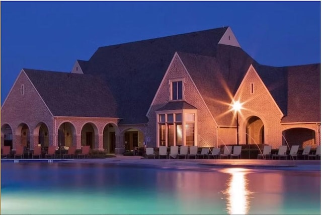 176 Summit Ct, Lavon, TX 75166 - pool at night featuring a community pool and a patio