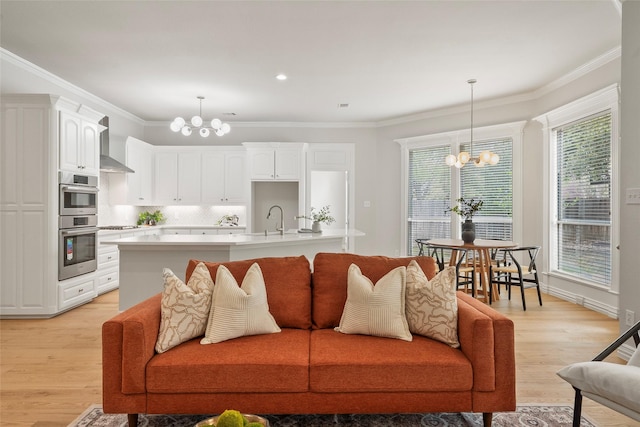living room with crown molding, light wood finished floors, a notable chandelier, and recessed lighting