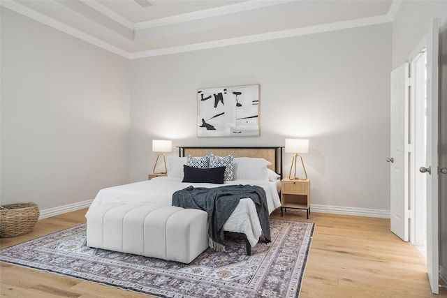 bedroom with ornamental molding, baseboards, and light wood-style floors