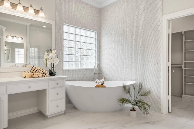 bathroom with a freestanding bath, marble finish floor, crown molding, and vanity