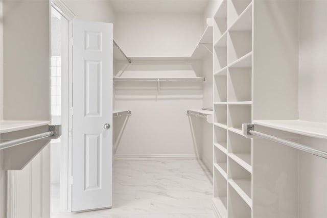 walk in closet with marble finish floor