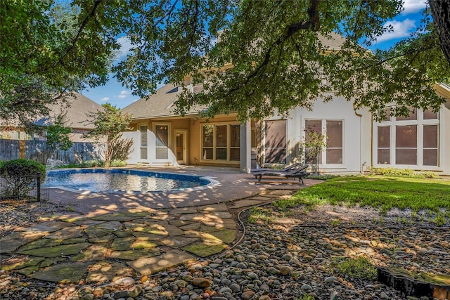 back of property with a patio area, fence, a fenced in pool, and stucco siding