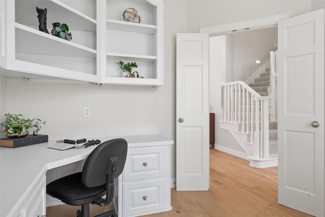 office space with built in study area and light wood finished floors