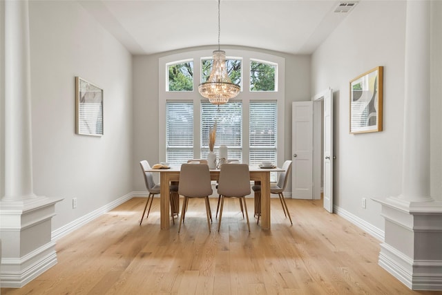 dining area featuring a notable chandelier, baseboards, light wood-style flooring, visible vents, and decorative columns