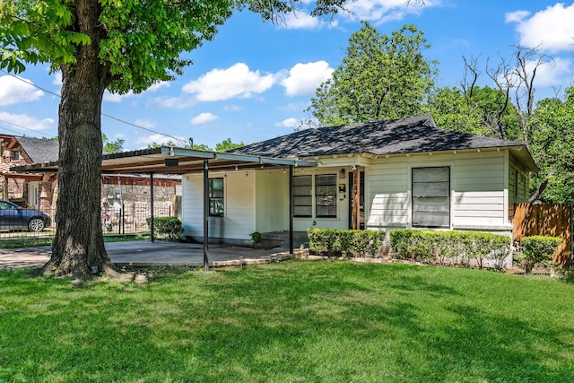 ranch-style home with fence, an attached carport, and a front yard