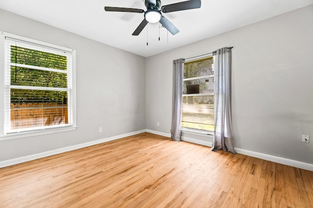 empty room featuring light wood-style flooring, baseboards, and a ceiling fan