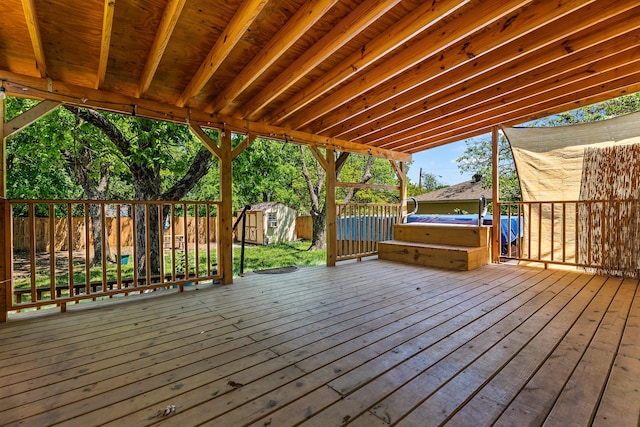 wooden deck featuring a storage unit, an outbuilding, and a fenced backyard