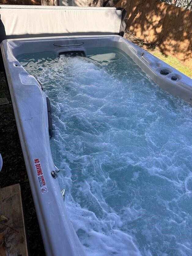 view of pool with a hot tub
