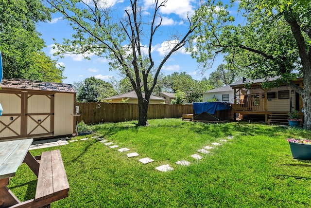 view of yard featuring a fenced backyard, an outdoor structure, a storage shed, and a deck