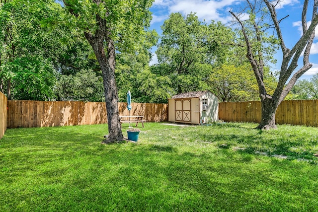 view of yard with a fenced backyard, an outdoor structure, and a storage shed