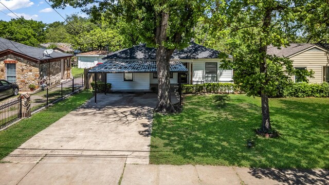 view of front of house featuring driveway, a front lawn, fence, and a carport