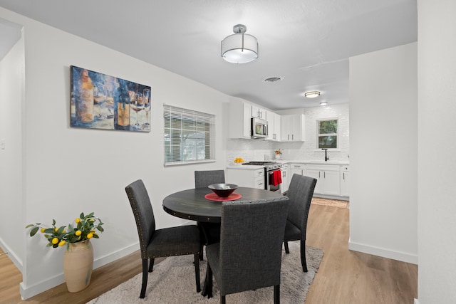 811 N Cooper St, Arlington, TX 76011 - dining space with healthy amount of natural light, light wood-style flooring, and baseboards