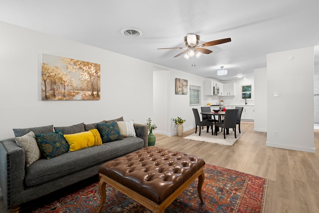 811 N Cooper St, Arlington, TX 76011 - living area with light wood finished floors, a ceiling fan, and baseboards