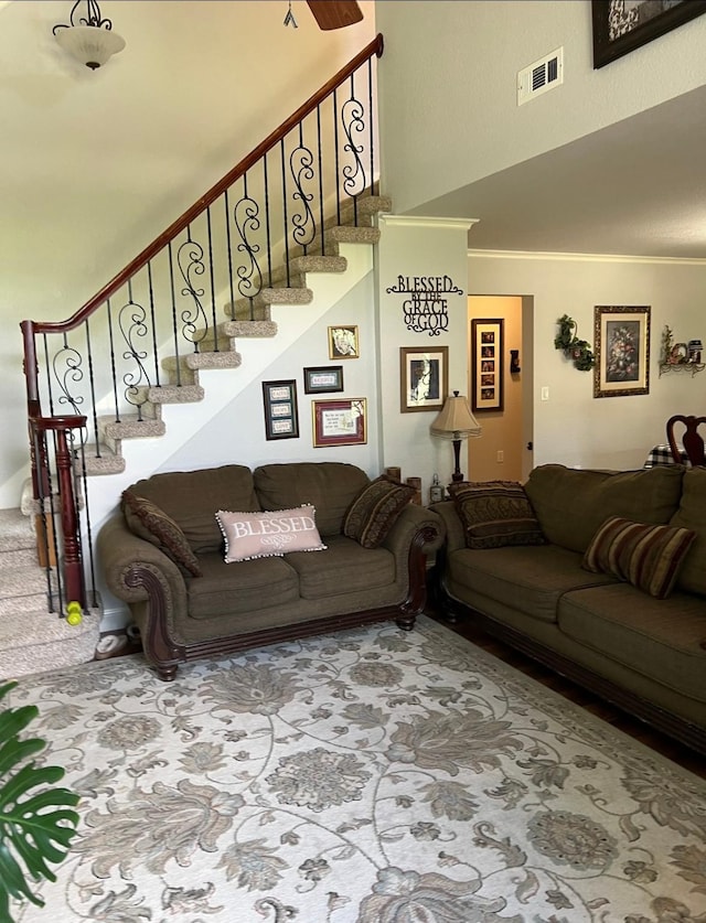 living room featuring stairway, visible vents, and a towering ceiling