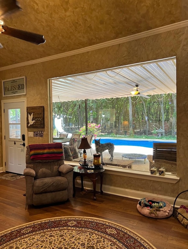 sitting room with hardwood / wood-style floors, ornamental molding, a ceiling fan, and a wealth of natural light