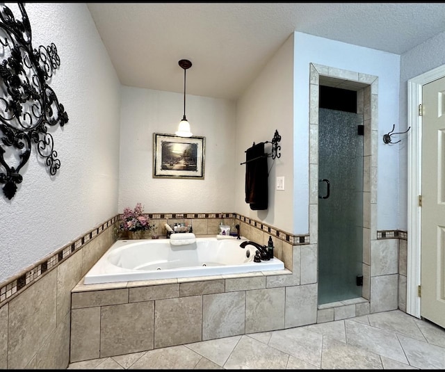 bathroom featuring a stall shower, tile patterned floors, a tub with jets, and a textured ceiling