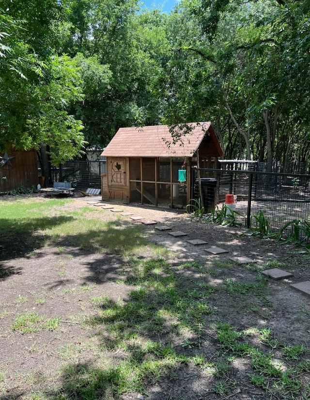view of yard with fence, exterior structure, and an outbuilding