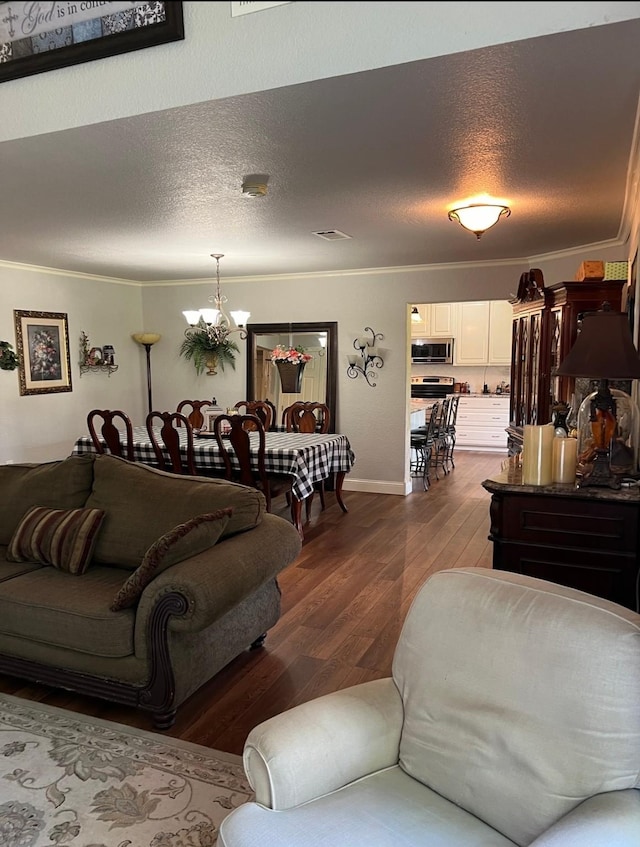 living area with crown molding, a textured ceiling, a chandelier, and dark wood-style floors
