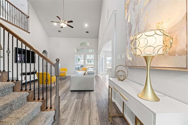 1036 Rutherford St, Frisco, TX 75036 - living area featuring high vaulted ceiling, stairway, ceiling fan, light wood finished floors, and arched walkways