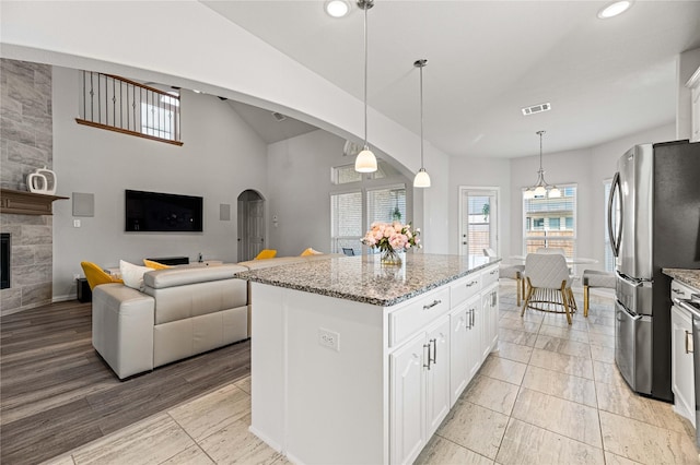 1036 Rutherford St, Frisco, TX 75036 - kitchen featuring freestanding refrigerator, a large fireplace, plenty of natural light, and visible vents