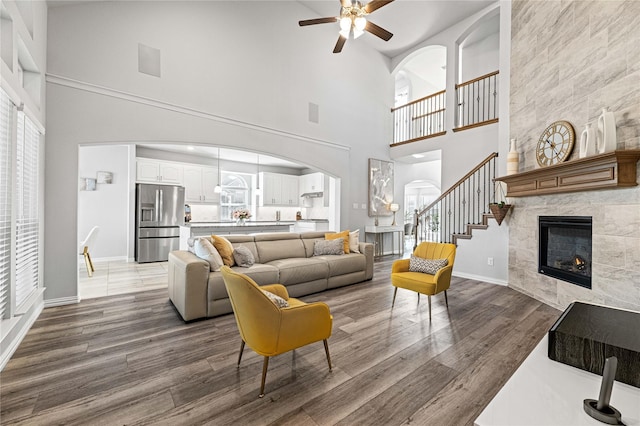 1036 Rutherford St, Frisco, TX 75036 - living area featuring a fireplace, arched walkways, high vaulted ceiling, and a ceiling fan