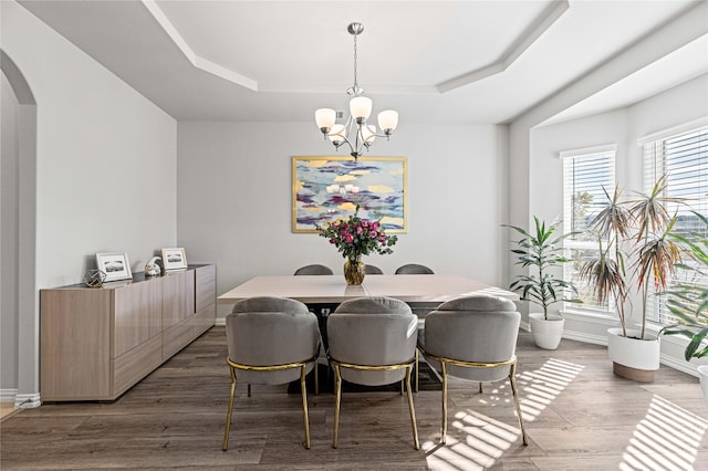 1036 Rutherford St, Frisco, TX 75036 - dining area featuring wood finished floors, a notable chandelier, baseboards, a raised ceiling, and arched walkways