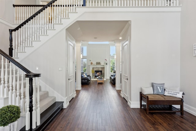 5205 Coral Springs Dr, Flower Mound, TX 75022 - foyer entrance featuring dark wood-style flooring, stairway, baseboards, and a warm lit fireplace