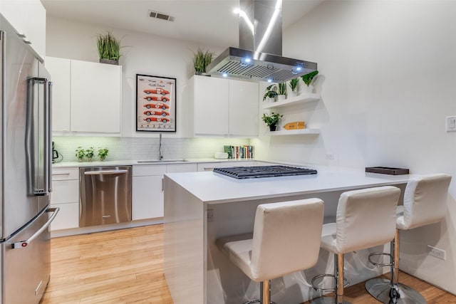 4401 Roseland Ave Unit A, Dallas, TX 75204 - kitchen with light wood-type flooring, a peninsula, stainless steel appliances, a sink, and ventilation hood