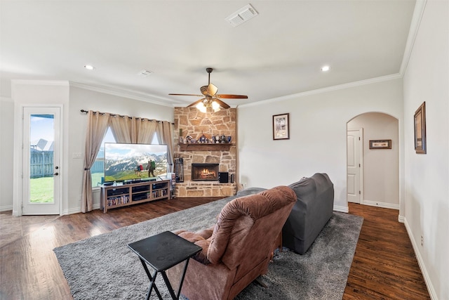 living area with visible vents, a ceiling fan, arched walkways, and wood finished floors