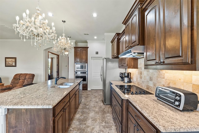 kitchen with an inviting chandelier, a sink, ornamental molding, under cabinet range hood, and stainless steel appliances