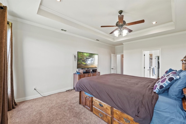 bedroom with ornamental molding, a tray ceiling, baseboards, and carpet flooring
