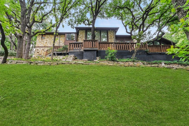 back of house with a yard, a deck, and stone siding