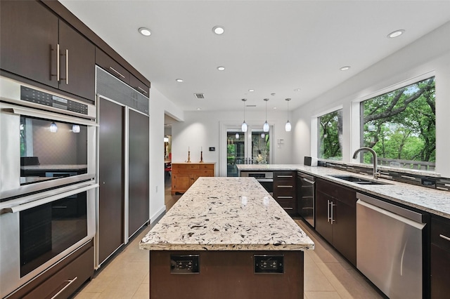 kitchen with a sink, stainless steel appliances, recessed lighting, and light tile patterned flooring