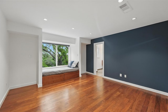 unfurnished room featuring recessed lighting, baseboards, visible vents, and wood finished floors