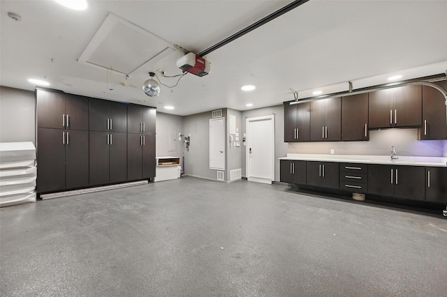 garage featuring a sink, a garage door opener, recessed lighting, and visible vents