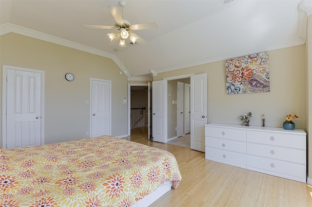 232 Wilshire Dr, Coppell, TX 75019 - bedroom with ornamental molding, a ceiling fan, light wood-style floors, multiple closets, and lofted ceiling