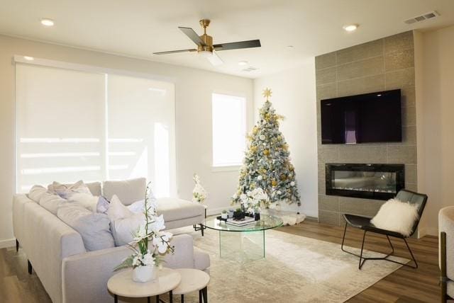 living area with visible vents, recessed lighting, a fireplace, wood finished floors, and a ceiling fan