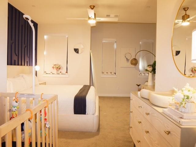bedroom featuring a nursery area, light carpet, and baseboards