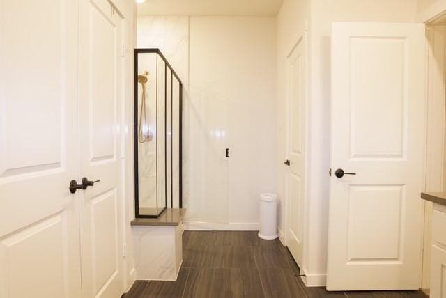 hallway with dark wood finished floors and baseboards