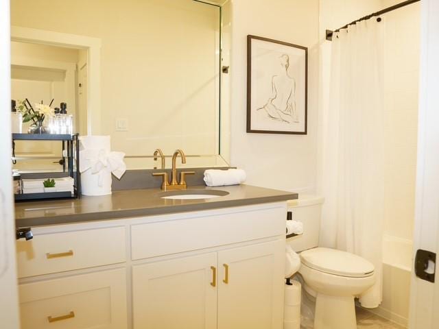 bathroom featuring shower / tub combo with curtain, toilet, and vanity