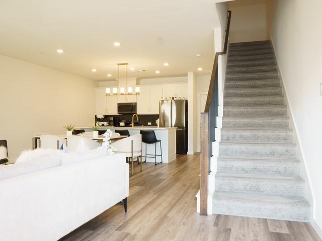 staircase featuring wood finished floors and recessed lighting