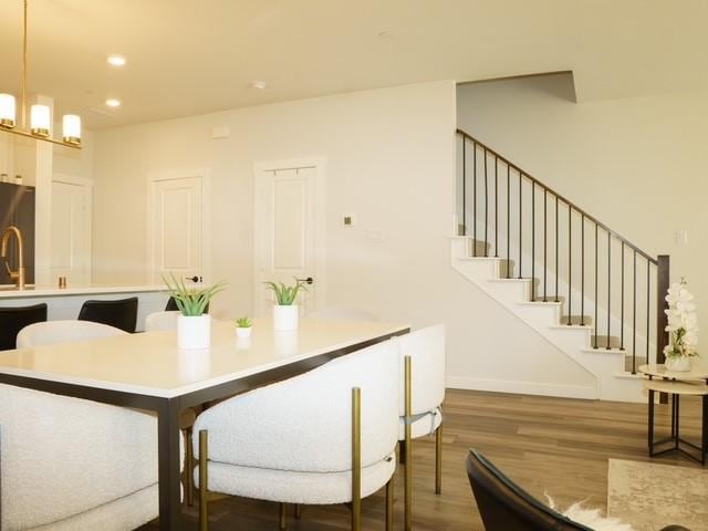 dining room featuring baseboards, recessed lighting, wood finished floors, and stairway
