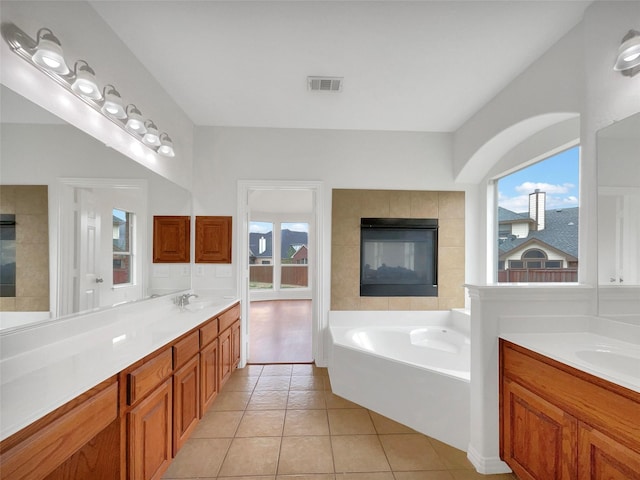 bathroom with plenty of natural light, tile patterned flooring, visible vents, and a garden tub