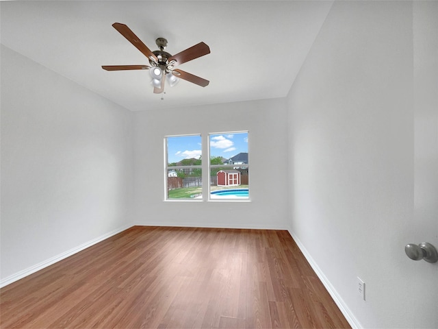 spare room with ceiling fan, baseboards, and wood finished floors