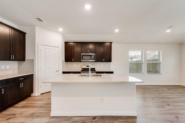 kitchen featuring appliances with stainless steel finishes, light wood-style floors, visible vents, and a sink
