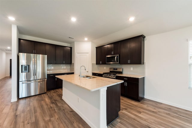kitchen featuring tasteful backsplash, baseboards, stainless steel appliances, and a sink