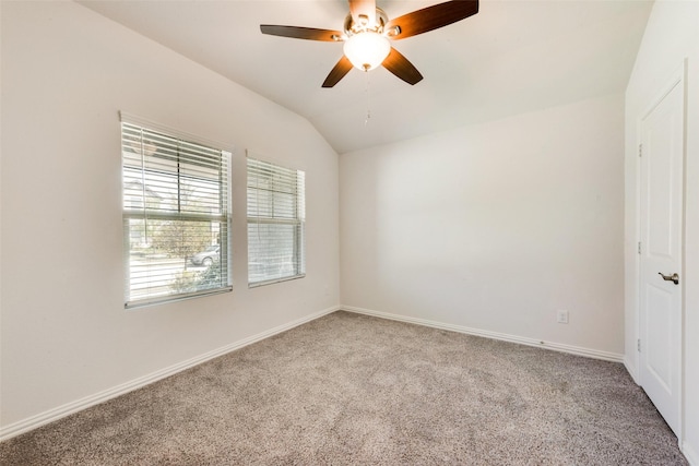 carpeted spare room with lofted ceiling, a ceiling fan, and baseboards