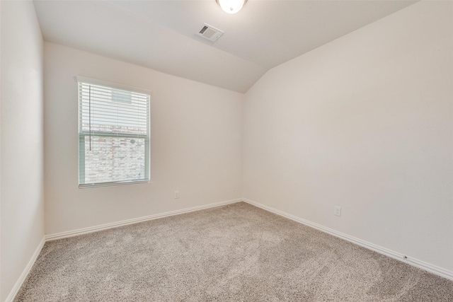 carpeted spare room featuring baseboards, vaulted ceiling, and visible vents