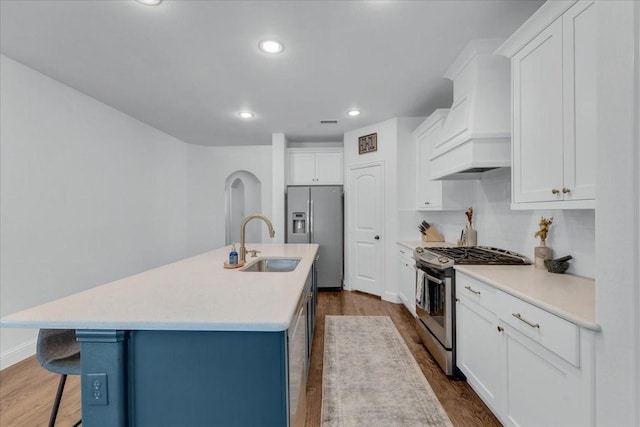 1102 Brigham Dr, Forney, TX 75126 - kitchen featuring stainless steel appliances, a sink, premium range hood, a kitchen breakfast bar, and white cabinets